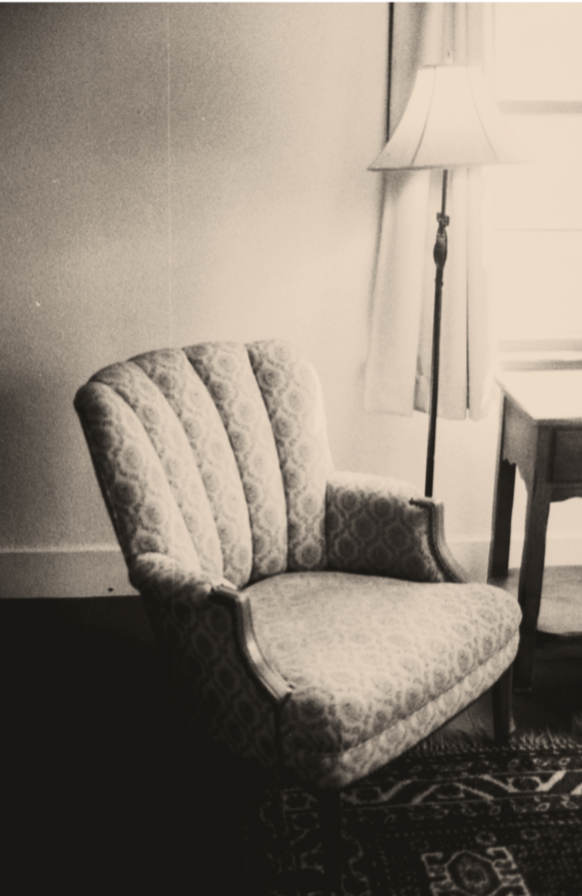 A vintage upholstered chair beside a floor lamp